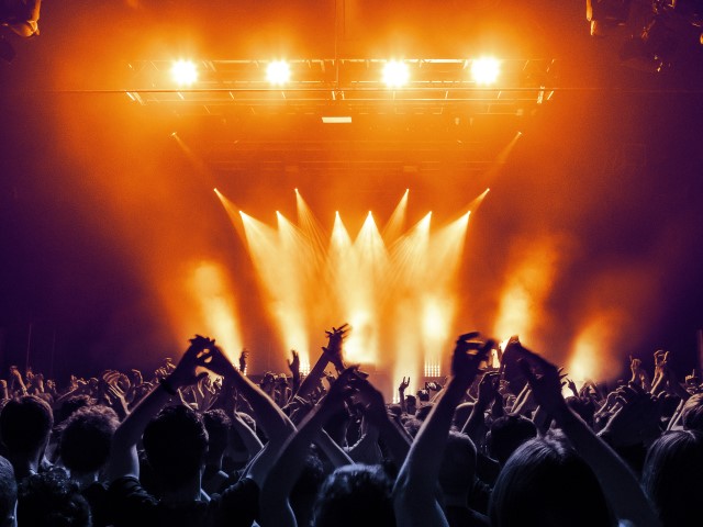 Concert,Hall,With,A,Lit,Stage,And,People,Silhouettes,During